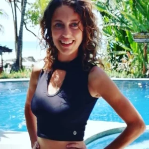 woman dressing top while standing near a pool