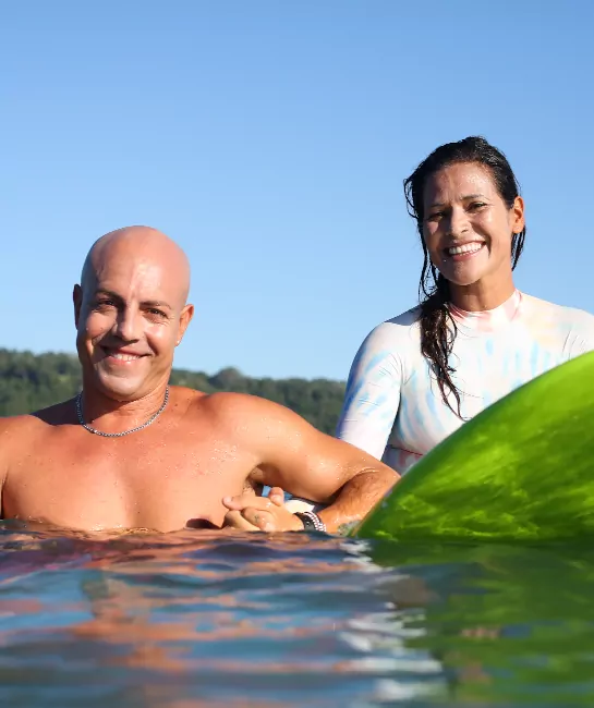 Man and woman riding a surfboard