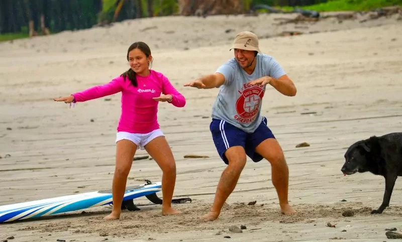 Girl receiving instructions from surf instructor on the beach