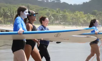 girls receiving a surf lesson