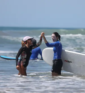 women celebrates successful surf lesson