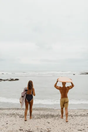 man and woman preparing to surf with their fish surfboards