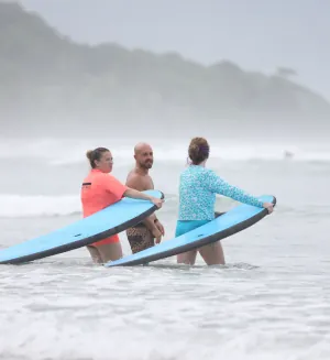 man giving instructions to female surfers